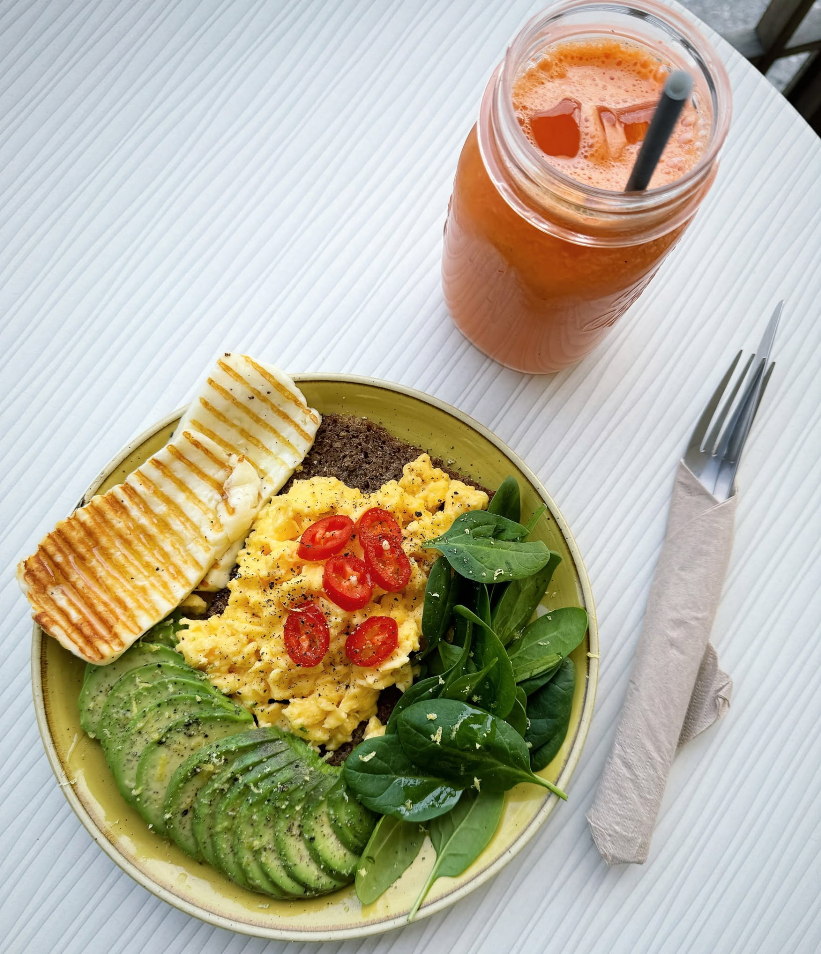 Crudo breakfast with scrambled eggs, avocado and fresh juice
